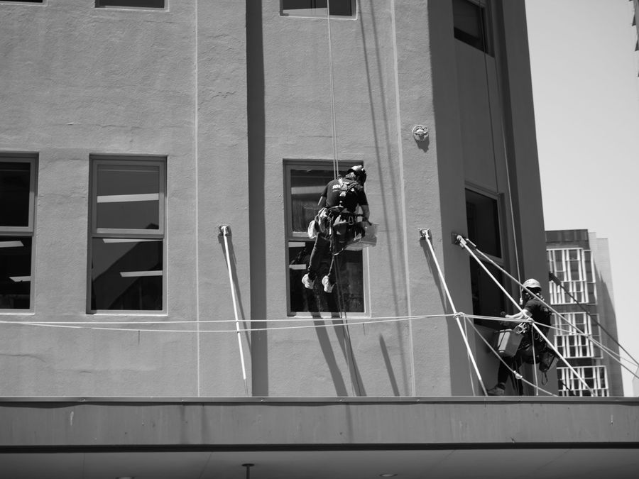 Técnicos trabajando suspendidos por cuerdas sobre la fachada de un edificio en altura